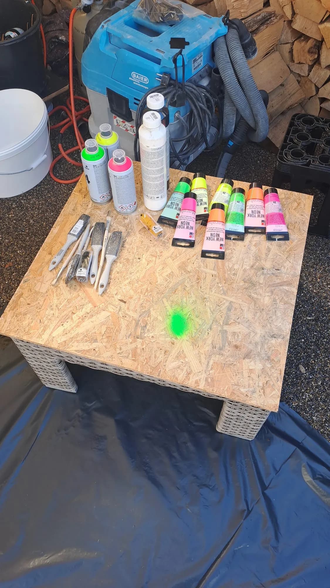 Werkzeug und Sprühfarben liegen auf dem Basteltisch bereit