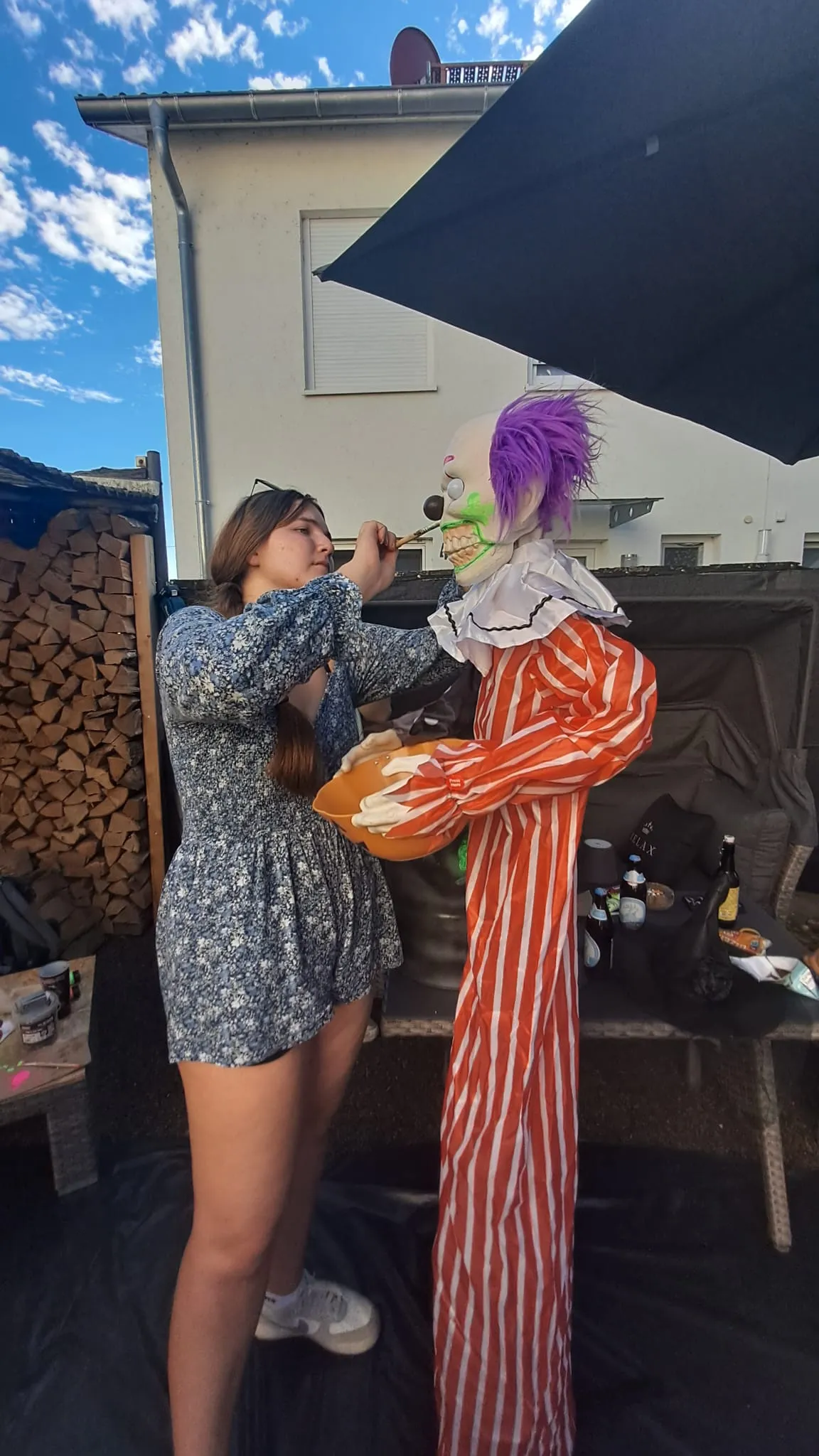 Eine Helferin bemalt eine Clownsfigur für das Horror Halloweenhaus